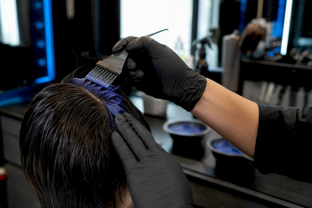 Barber applying hair color with brush