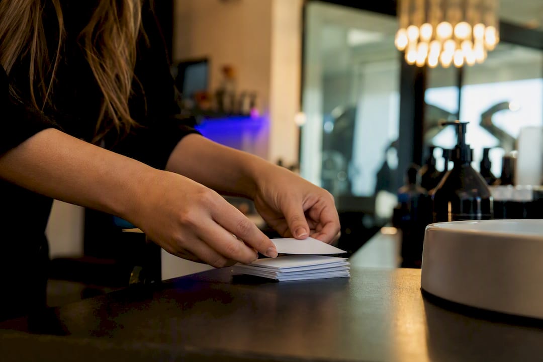 Stylist hands arranging rebooking reminder cards