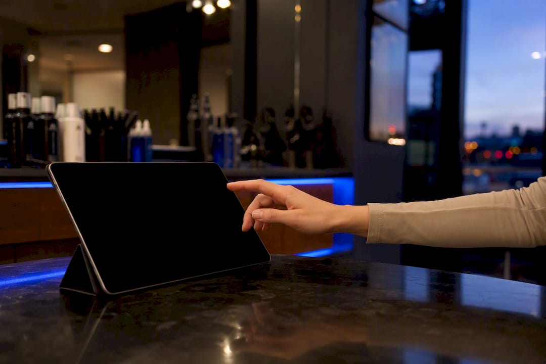 Hand holding tablet for email sign-up at salon reception