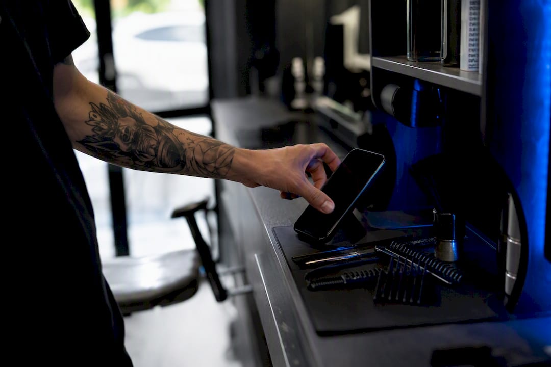 Hand tapping phone at salon to book appointment