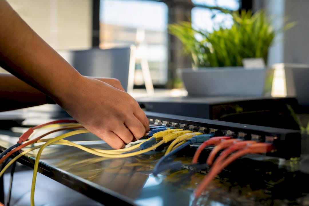 Hands connecting cables on hardware device