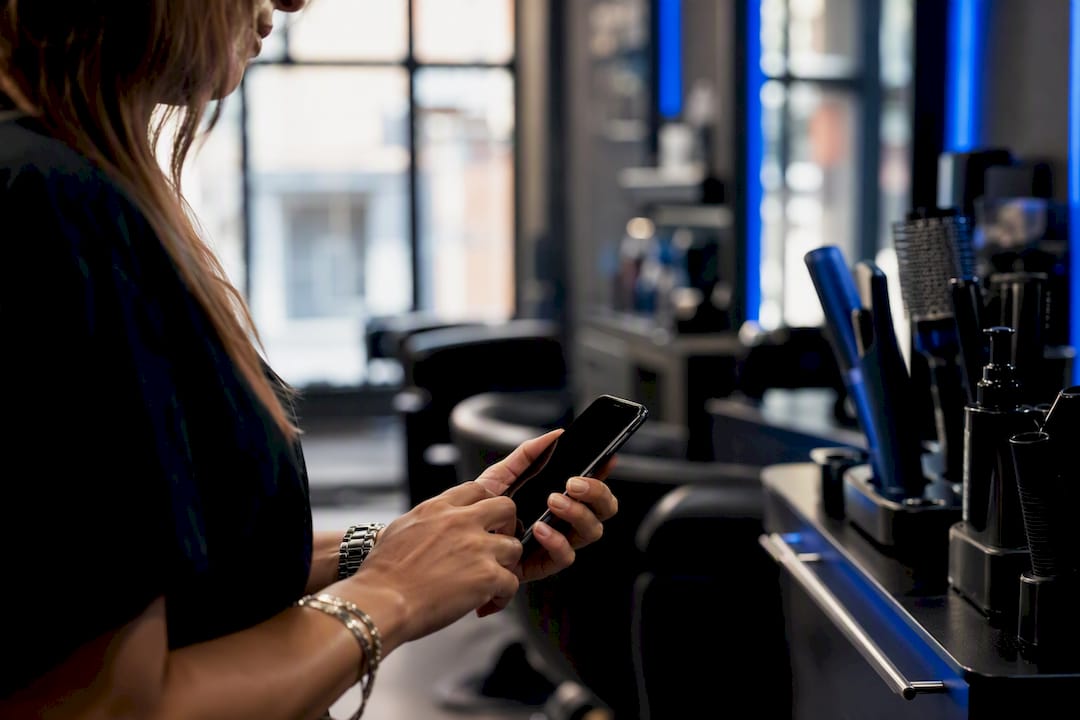 Stylist sending SMS reminder on phone