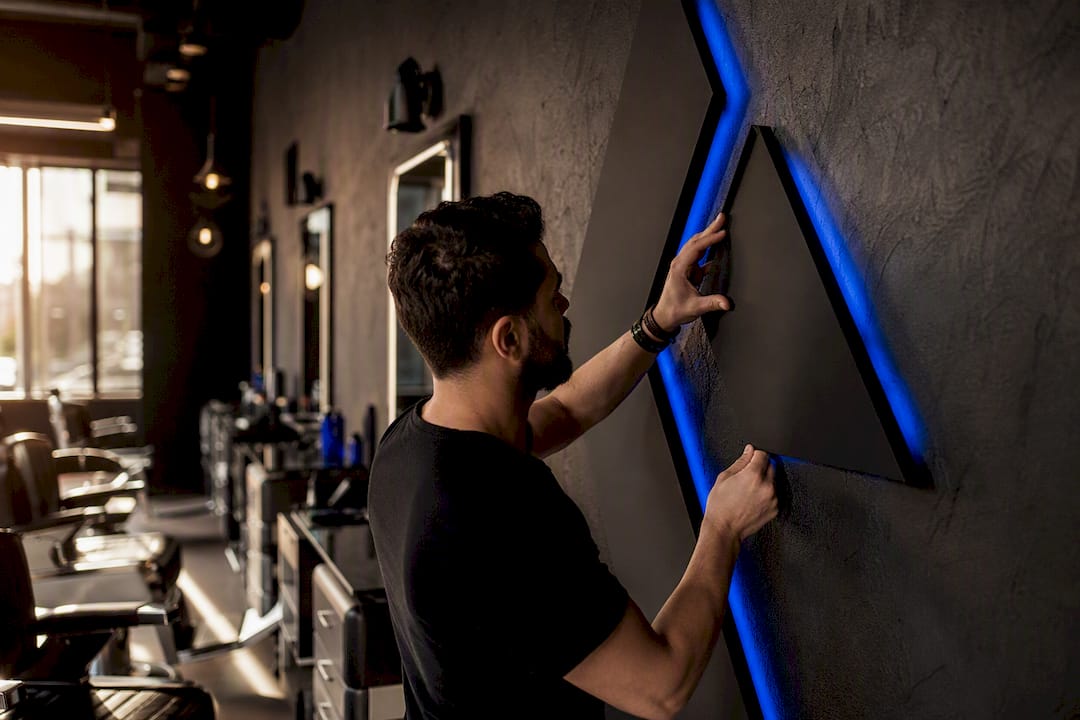 Barber adjusting salon branding decor