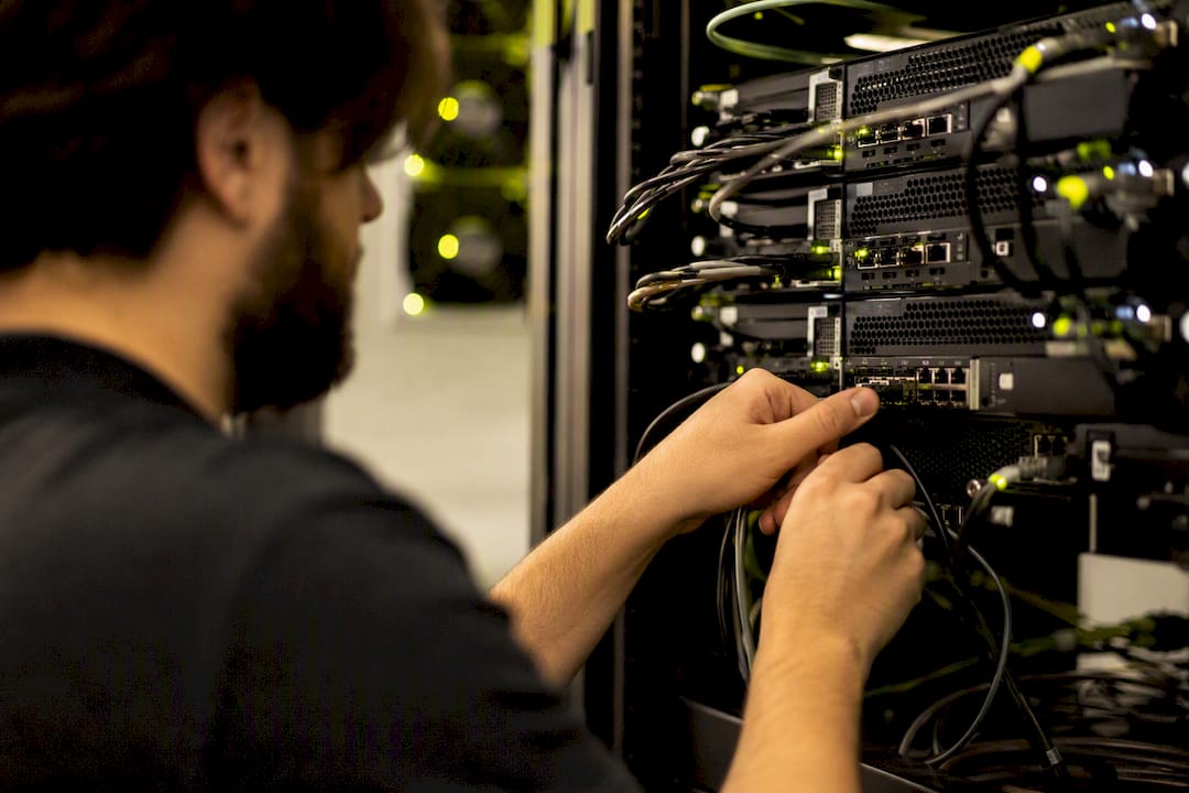 Hand connecting network cable to server