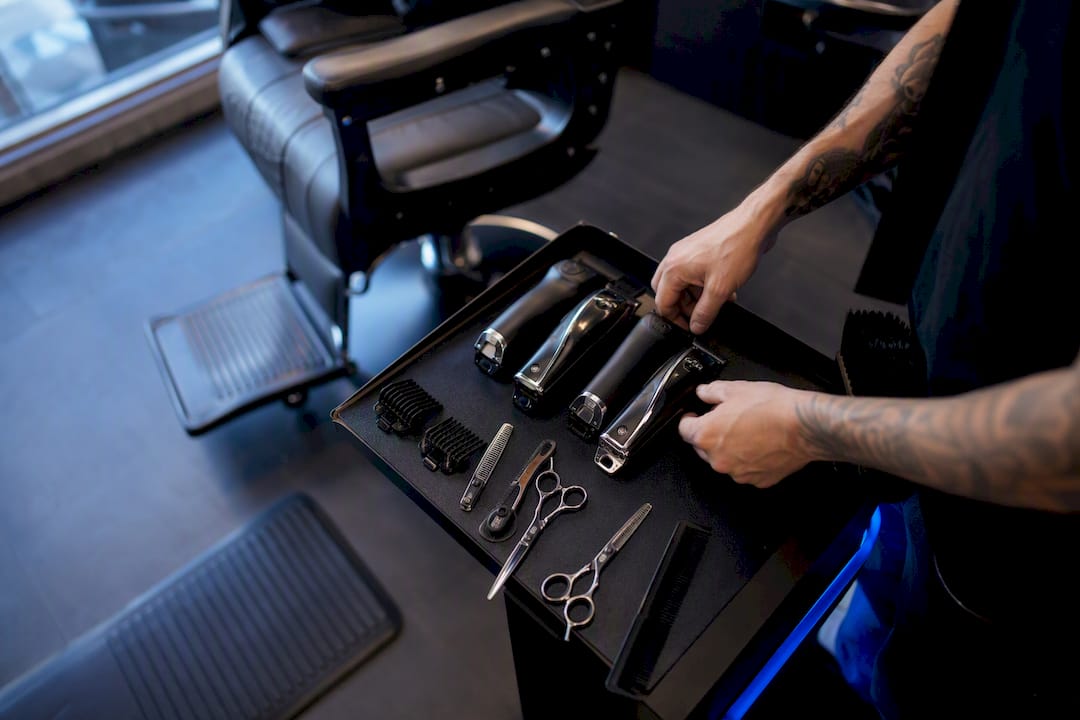Barber hands arranging clippers and scissors
