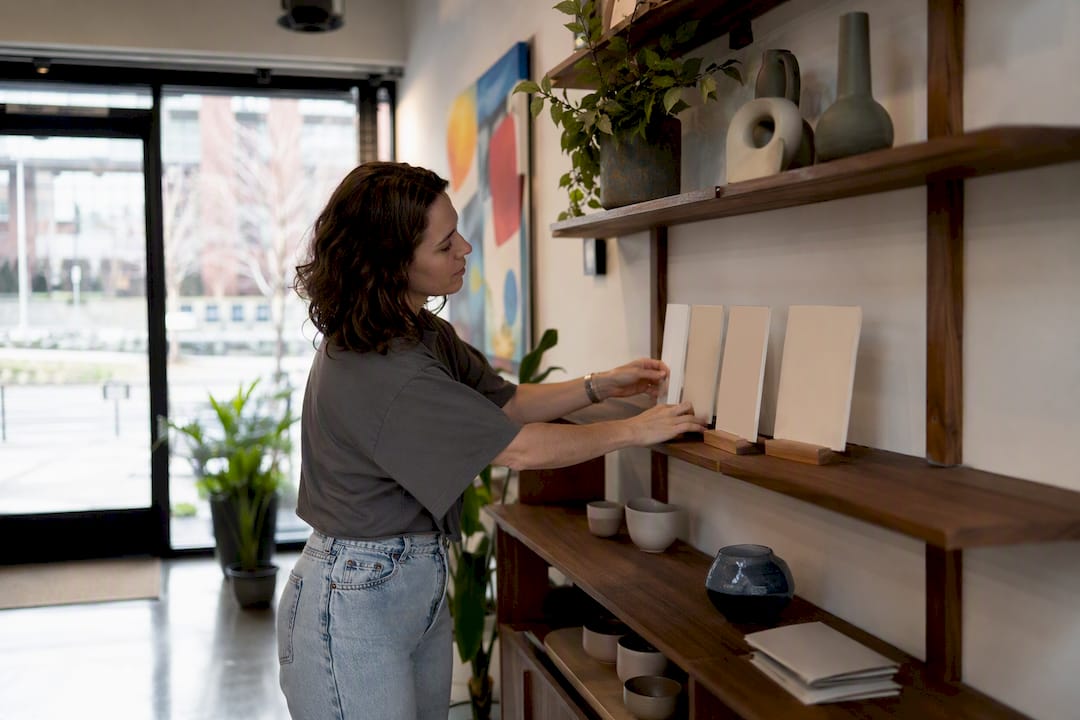 Hands arranging small business display for listing photo