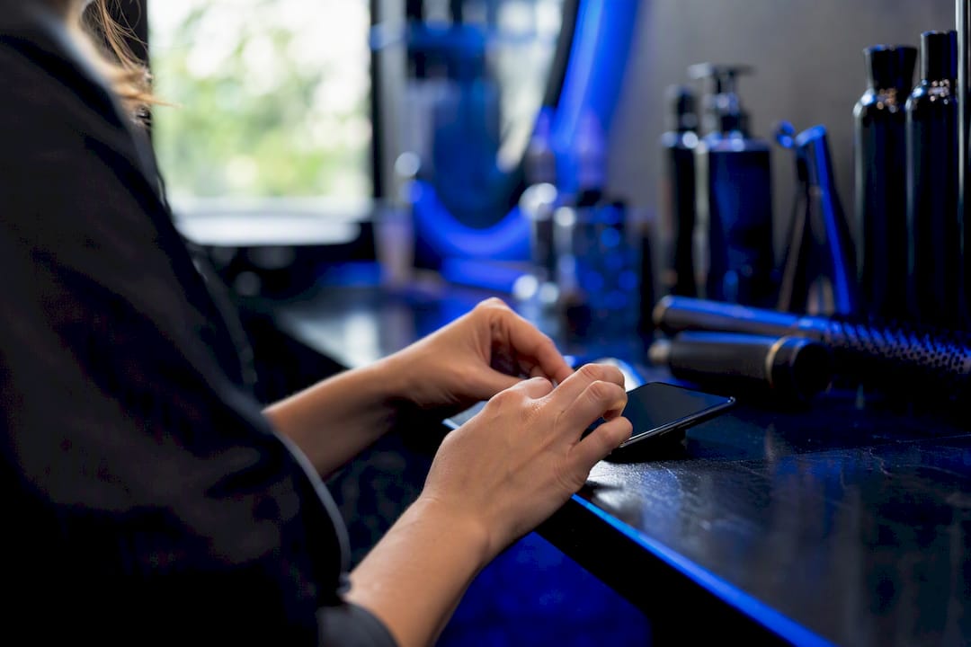Stylist updating salon booking on phone