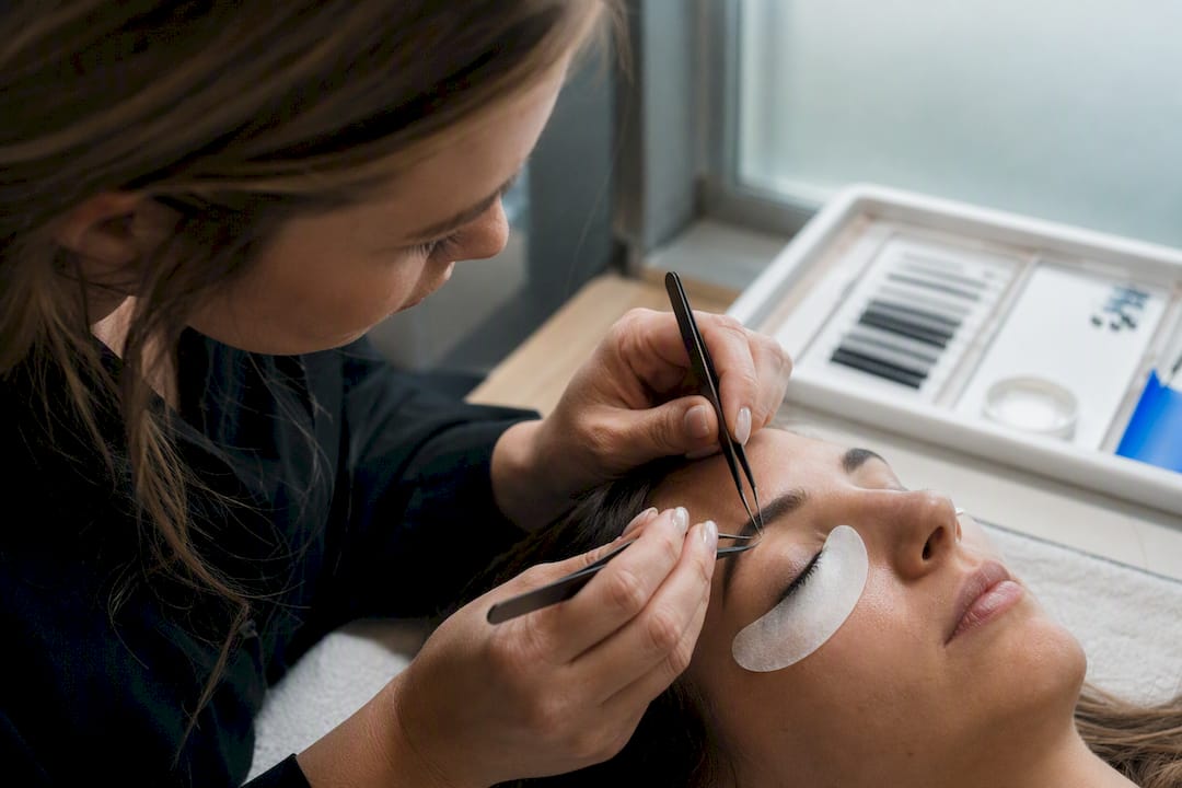Close-up of lash artist applying extensions