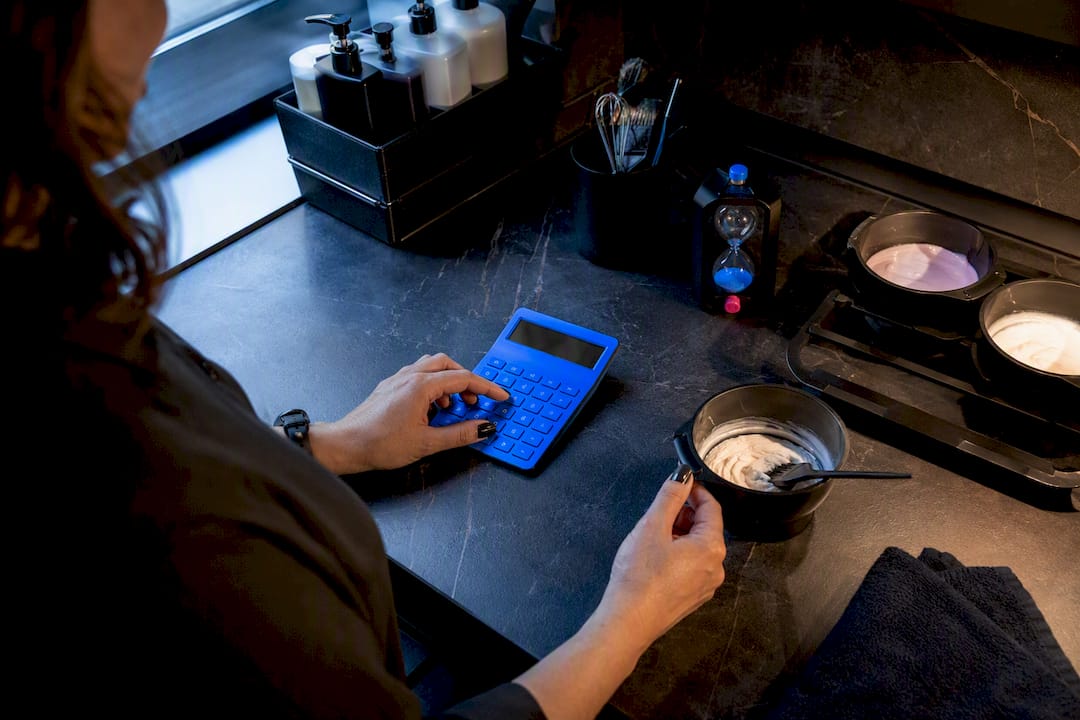 Salon owner calculating chair cost beside salon tools