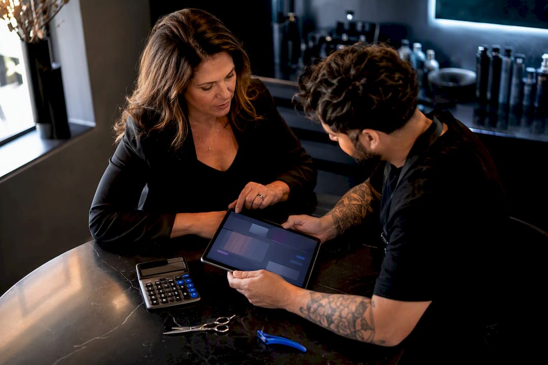 Salon owner reviewing stylist service pricing