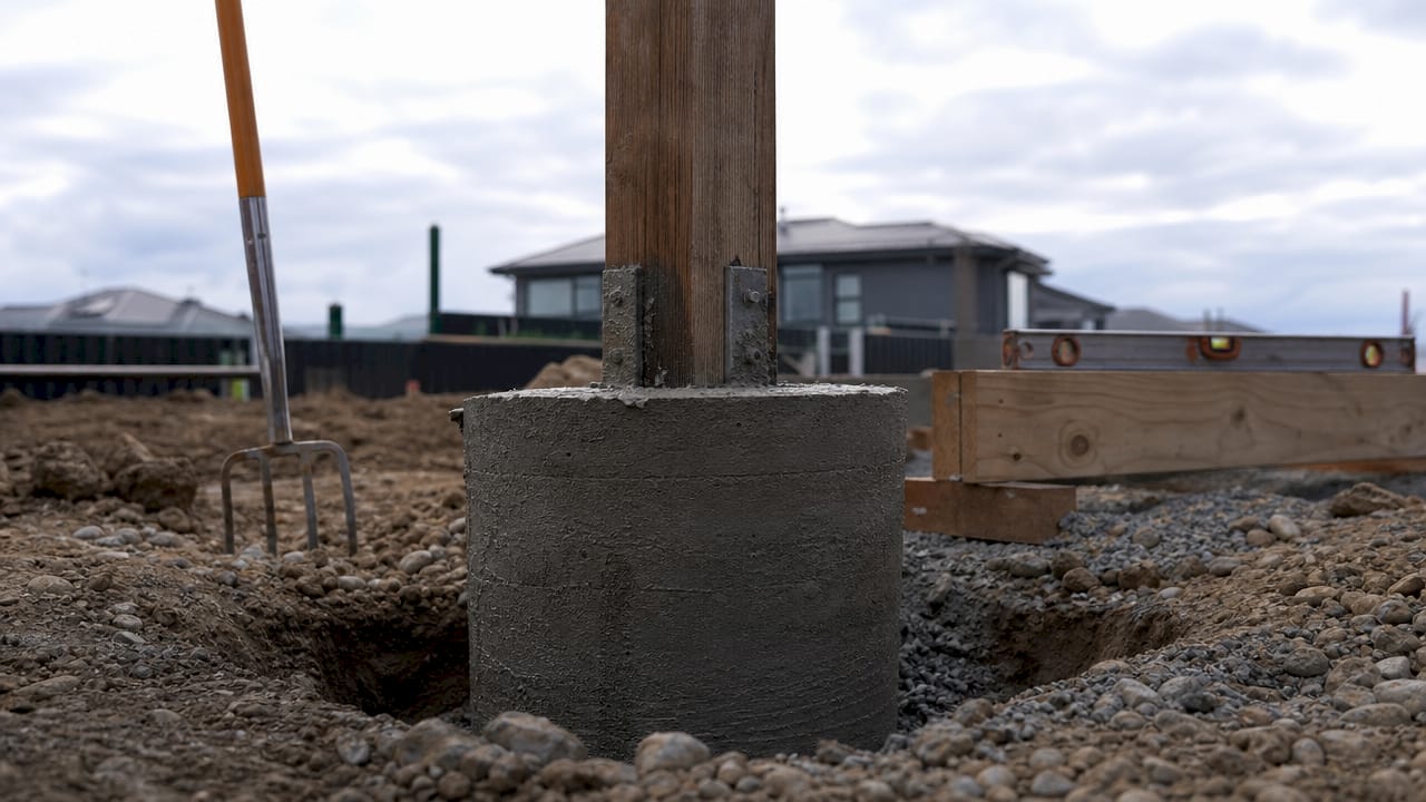 Close-up of concrete footing with timber post form