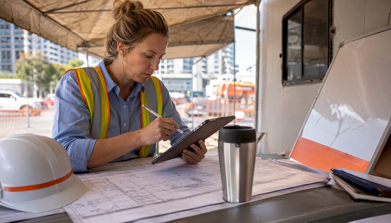 Site manager coordinating construction on tablet