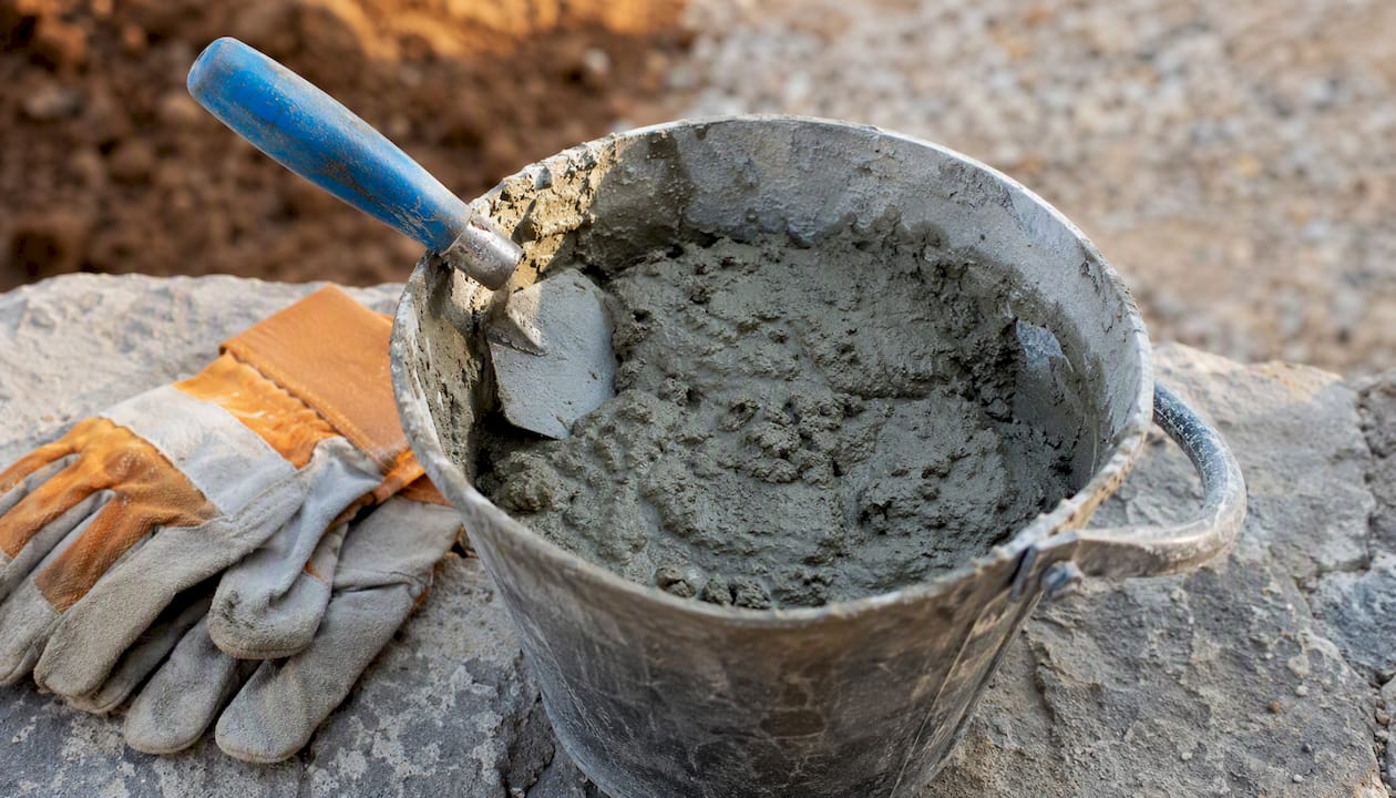 Concrete mix sample with trowel and gloves