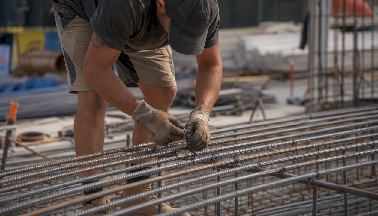 Hands tying rebar at construction site