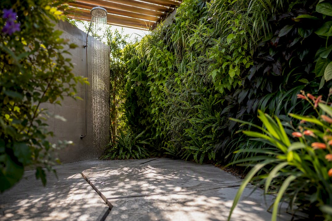 Outdoor shower with plant wall and pergola for privacy