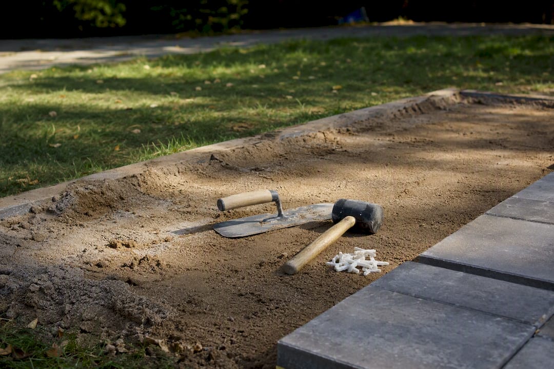 Sand bed and paving tools on driveway