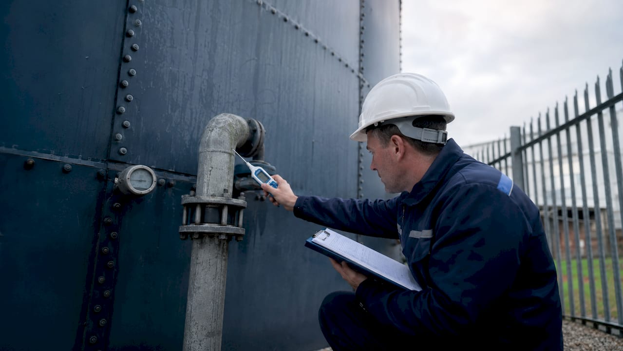 Water technician inspecting cold water storage tank