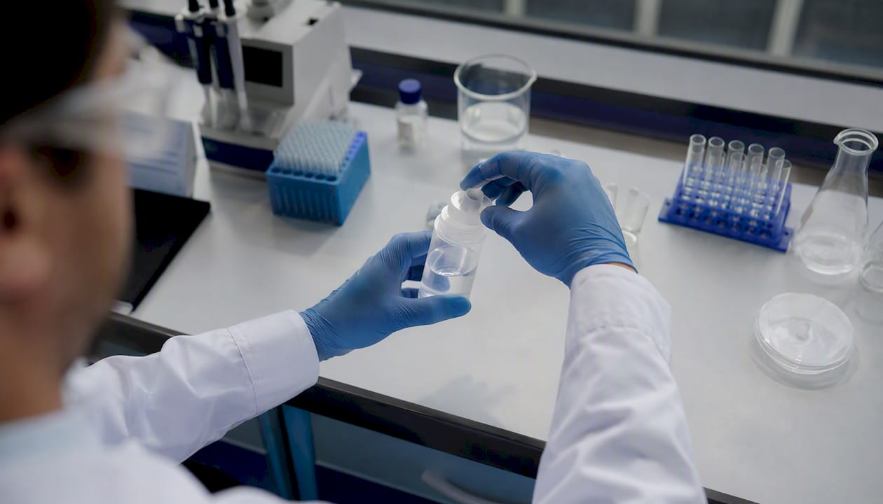 Lab technician handling water sample for testing
