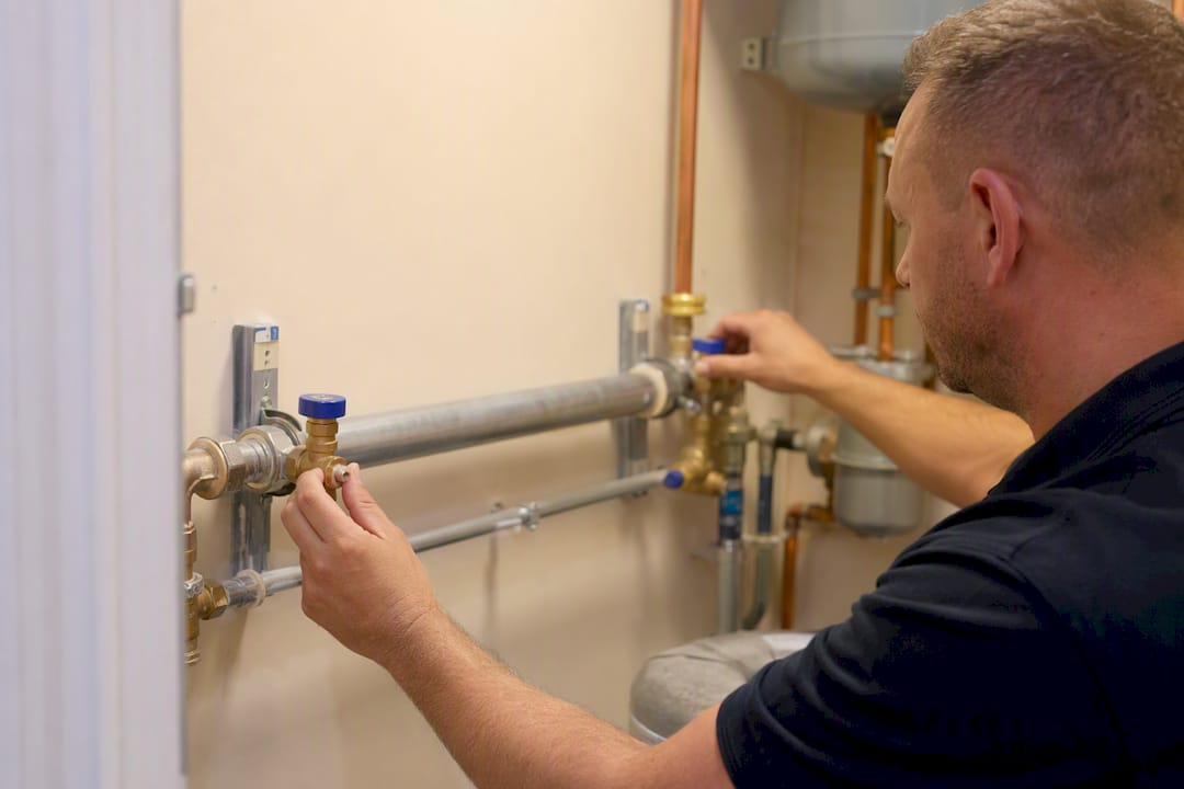 Hands inspecting sentinel taps on water pipes
