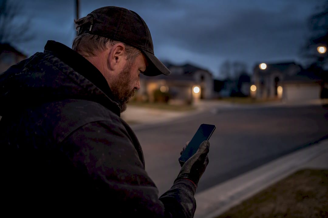 Contractor evaluating messages on smartphone outdoors