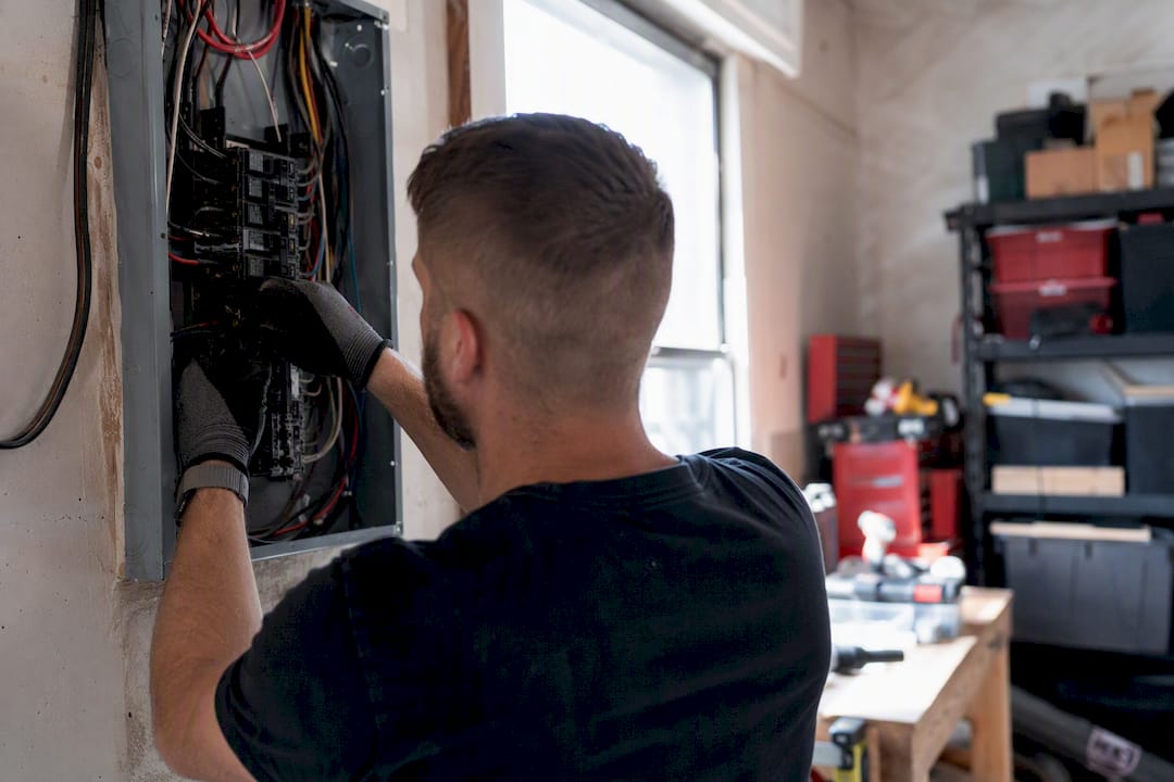 Electrician installing circuit breaker close-up