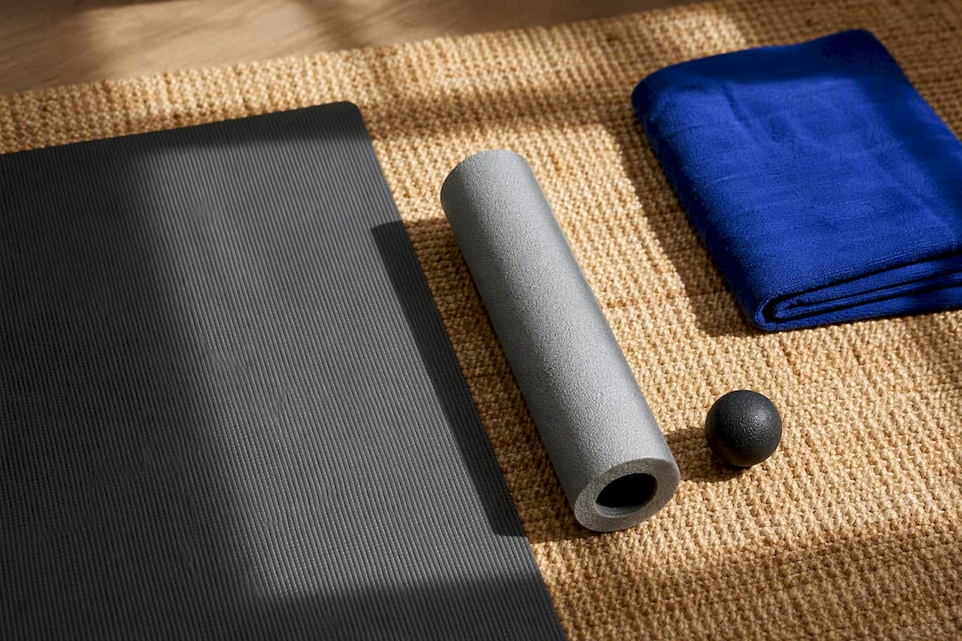 Foam roller and soft ball beside practice mat
