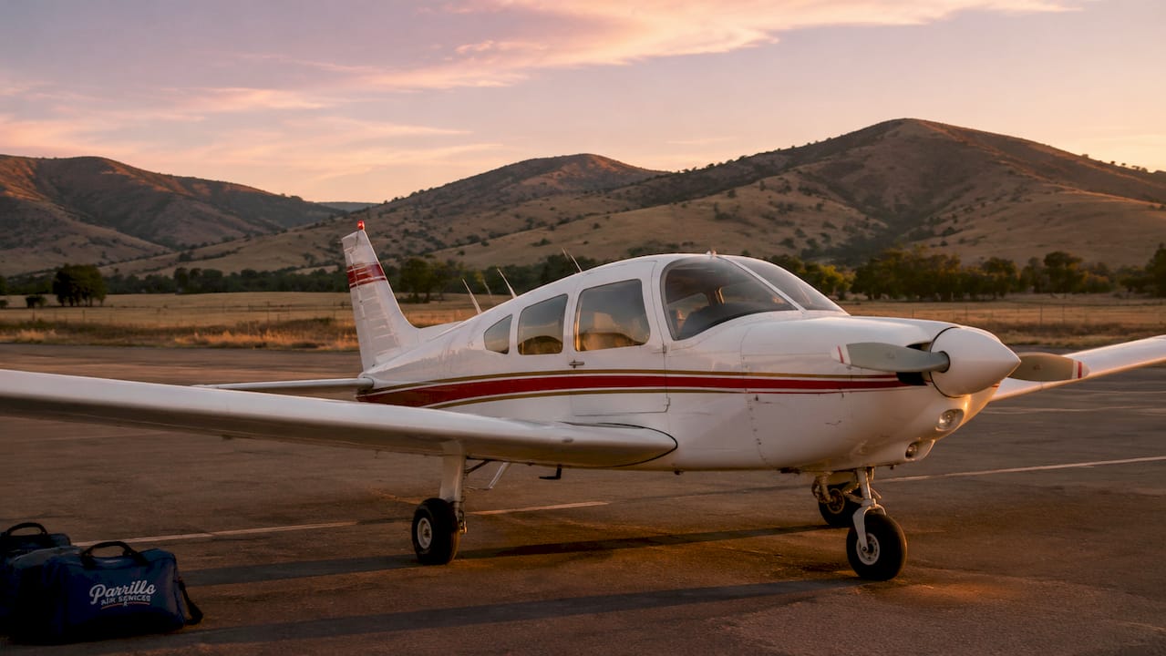 Low-wing Piper Cherokee aircraft side view on airfield