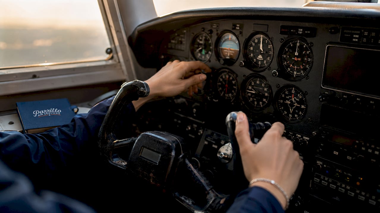Pilot's hands operating aircraft instruments overhead