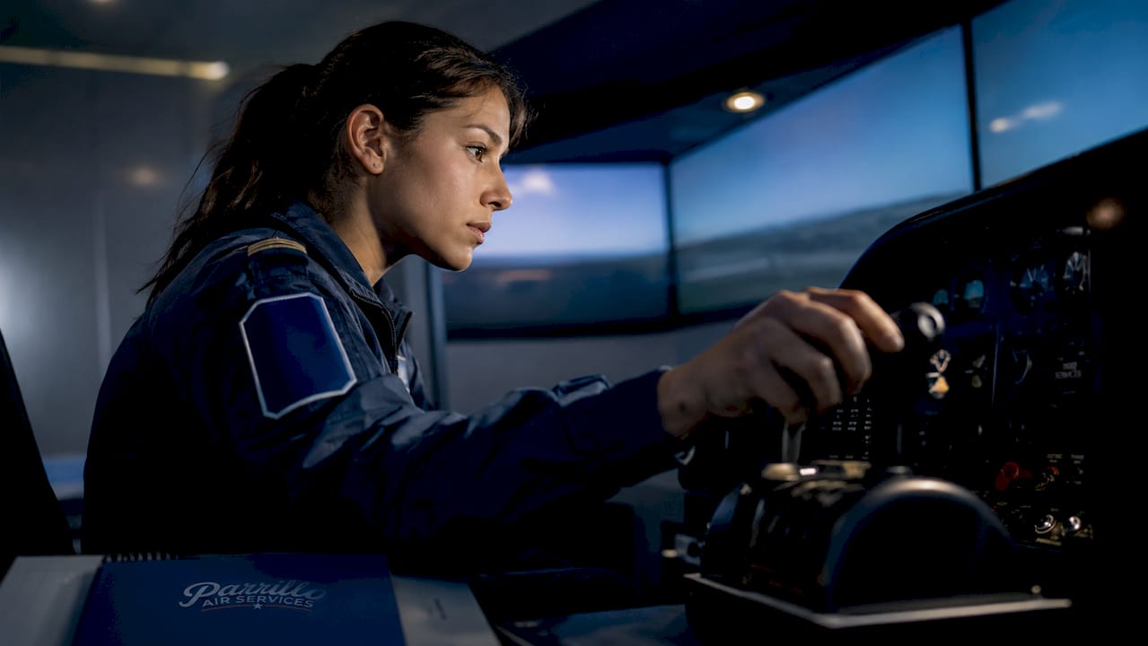Female pilot operating training aircraft cockpit