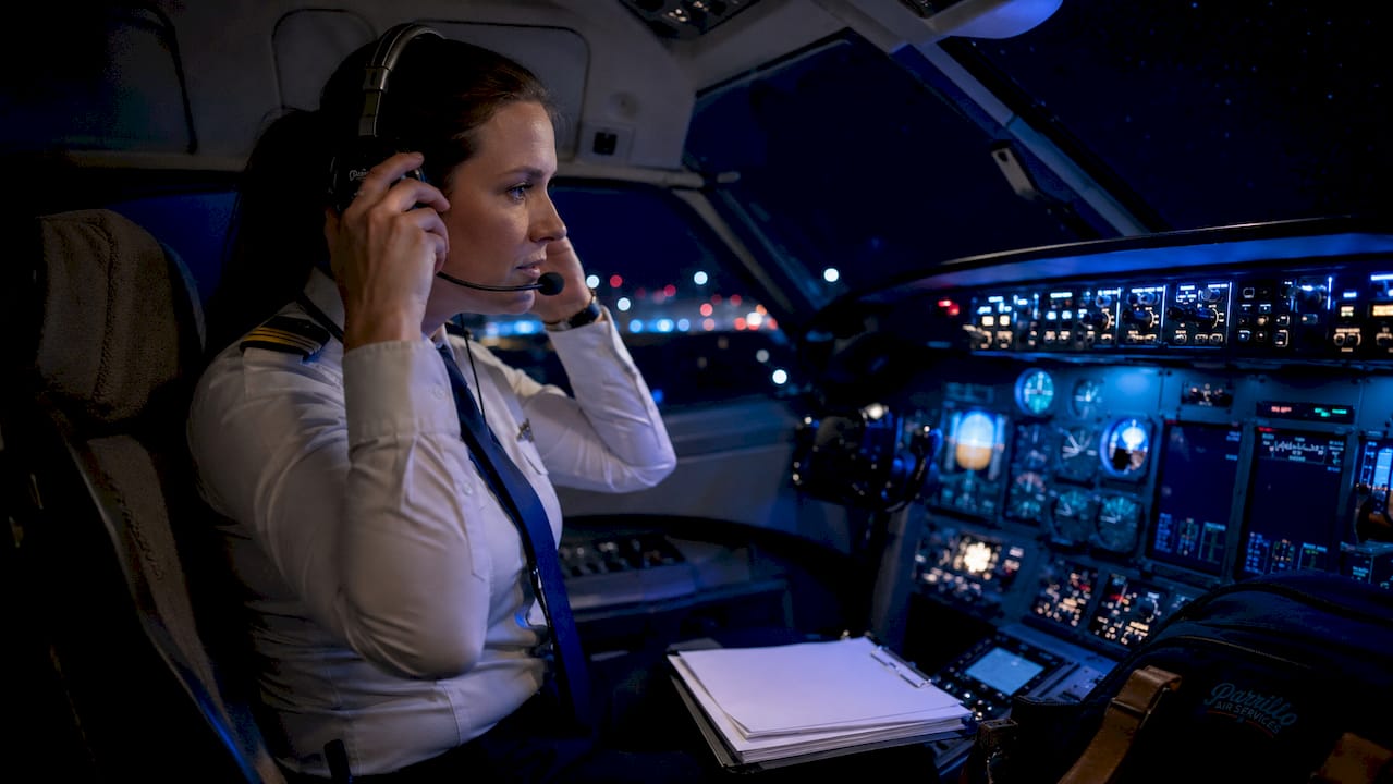 Female pilot preparing cockpit for night flight