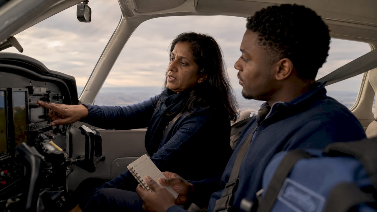 Flight instructor coaching student in training aircraft cockpit