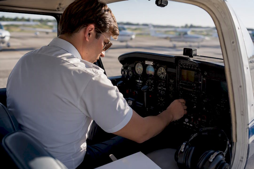 Pilot checking controls in aircraft cockpit