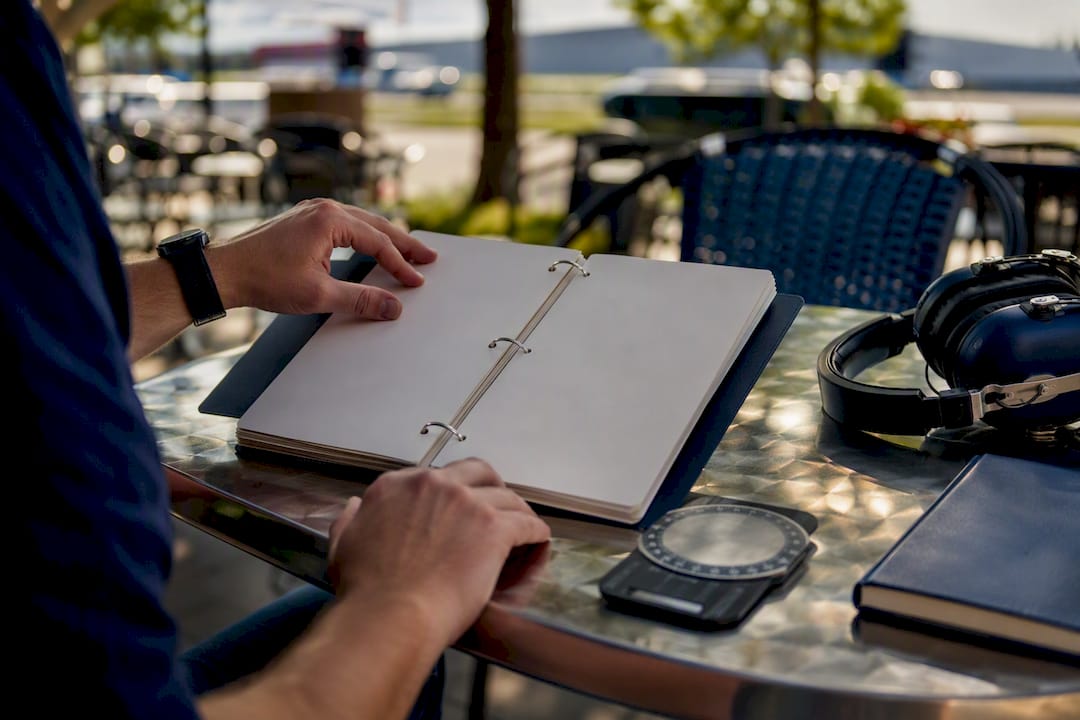 Student pilot hands pointing at checklist in policy binder