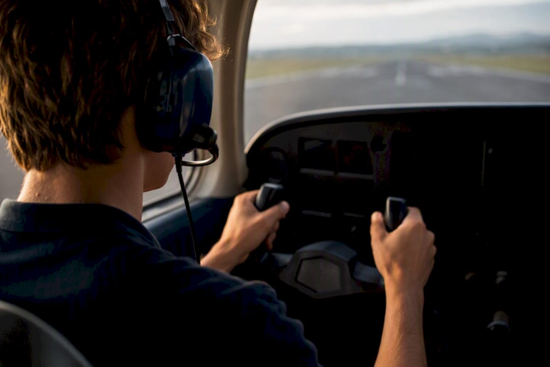 Student pilot operating cockpit controls solo