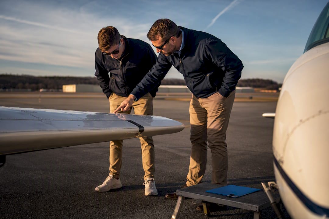 Student pilot and instructor beside training aircraft