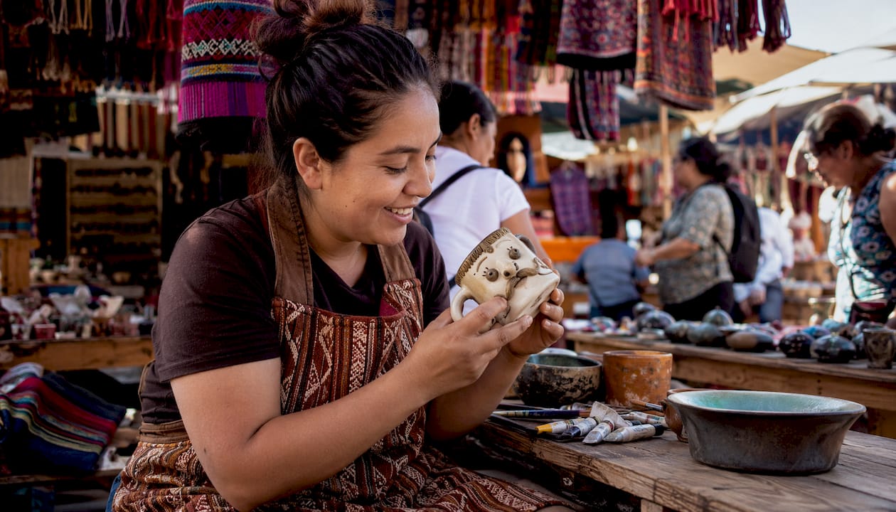 Craftswoman examining handmade funny mug