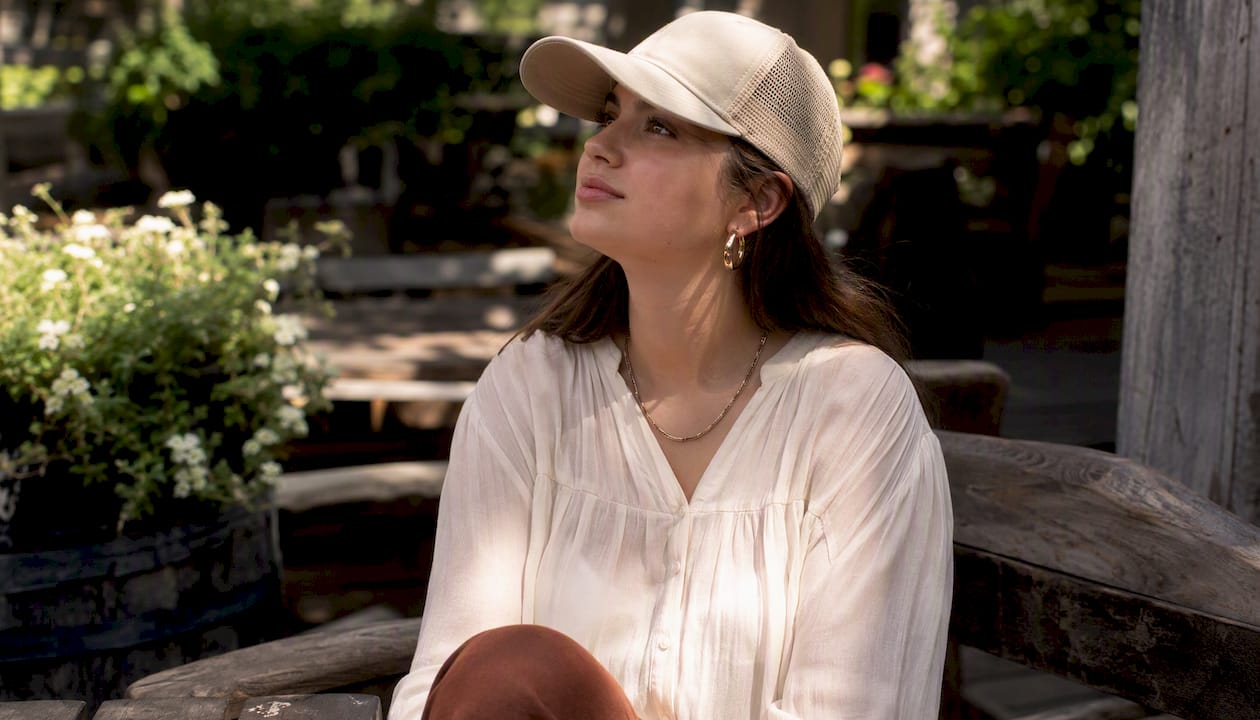Close-up feminine styling of trucker hat with accessories