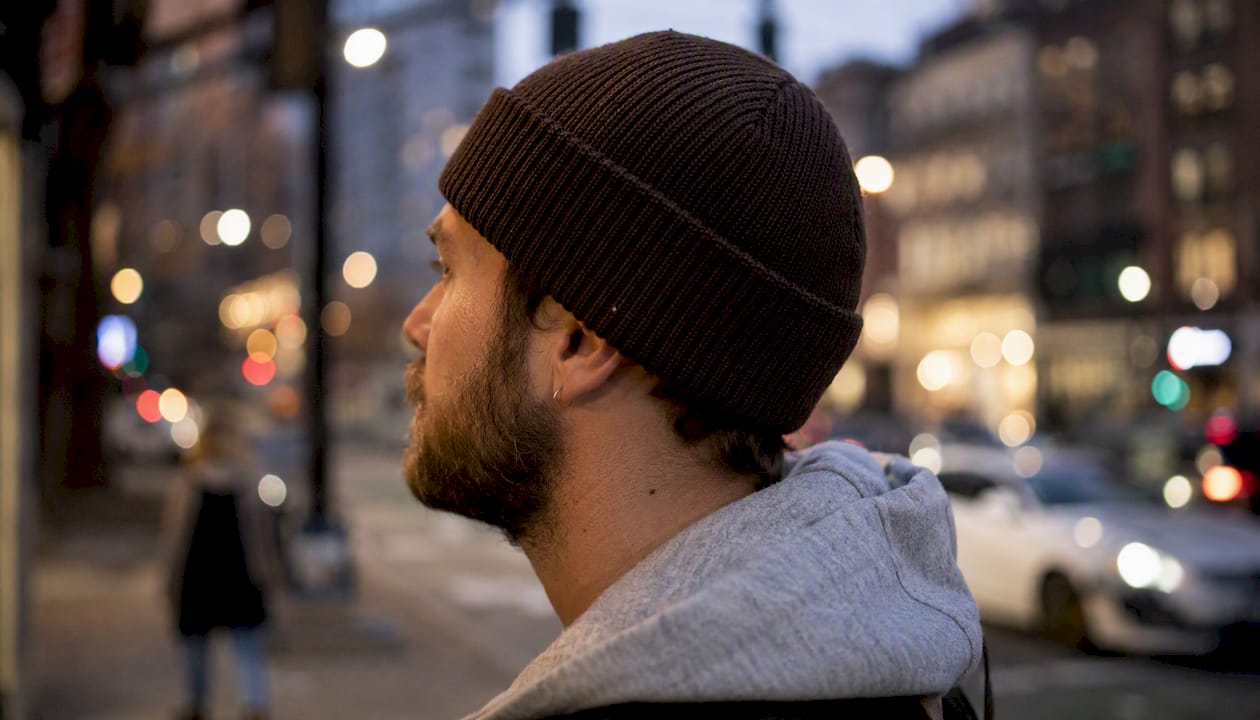 Person wearing fisherman beanie on city street