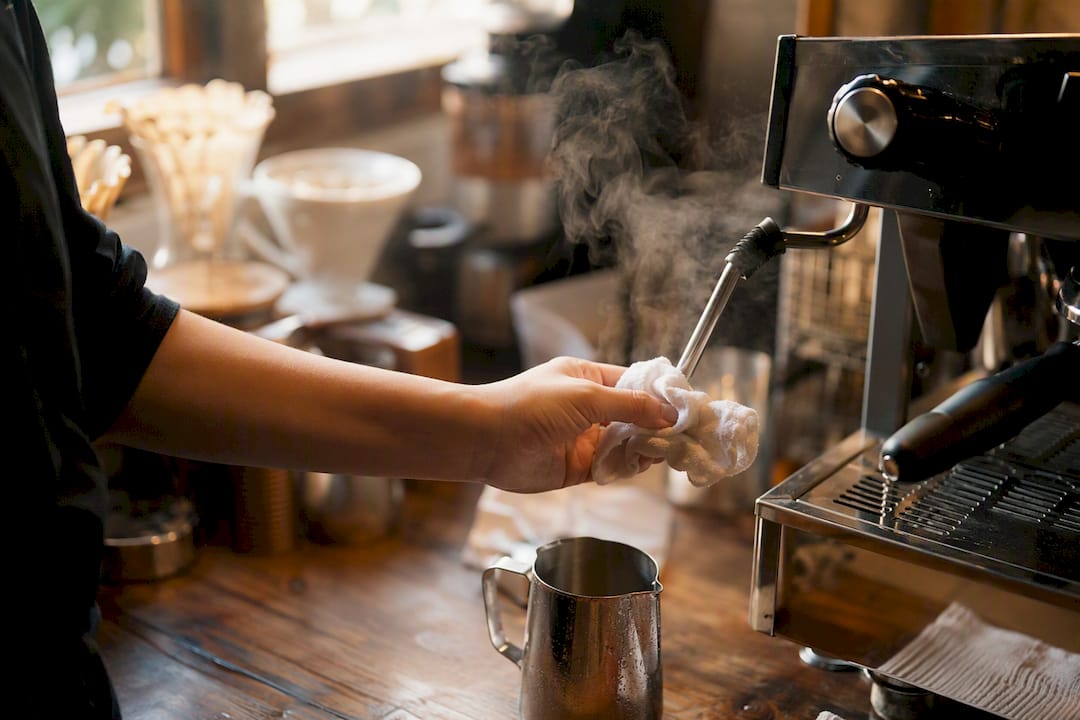 Barista cleaning espresso steamer wand