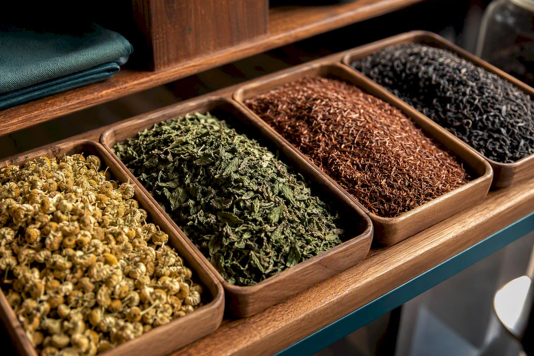 Herbal botanicals beside black tea leaves