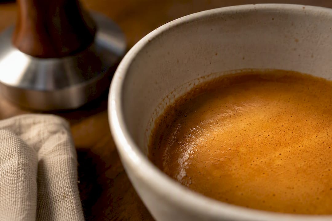 Crema resting inside a tapered espresso cup