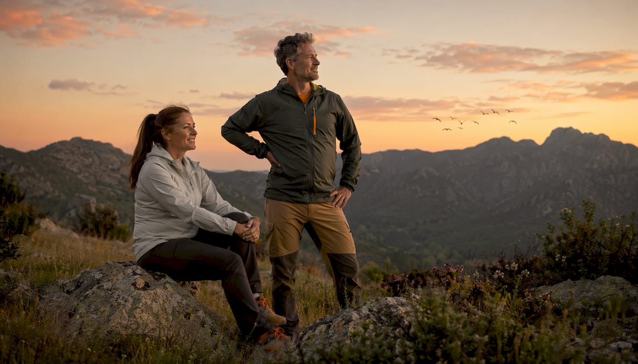 Una pareja se toma un merecido descanso después de recorrer juntos un sendero rodeado de naturaleza.