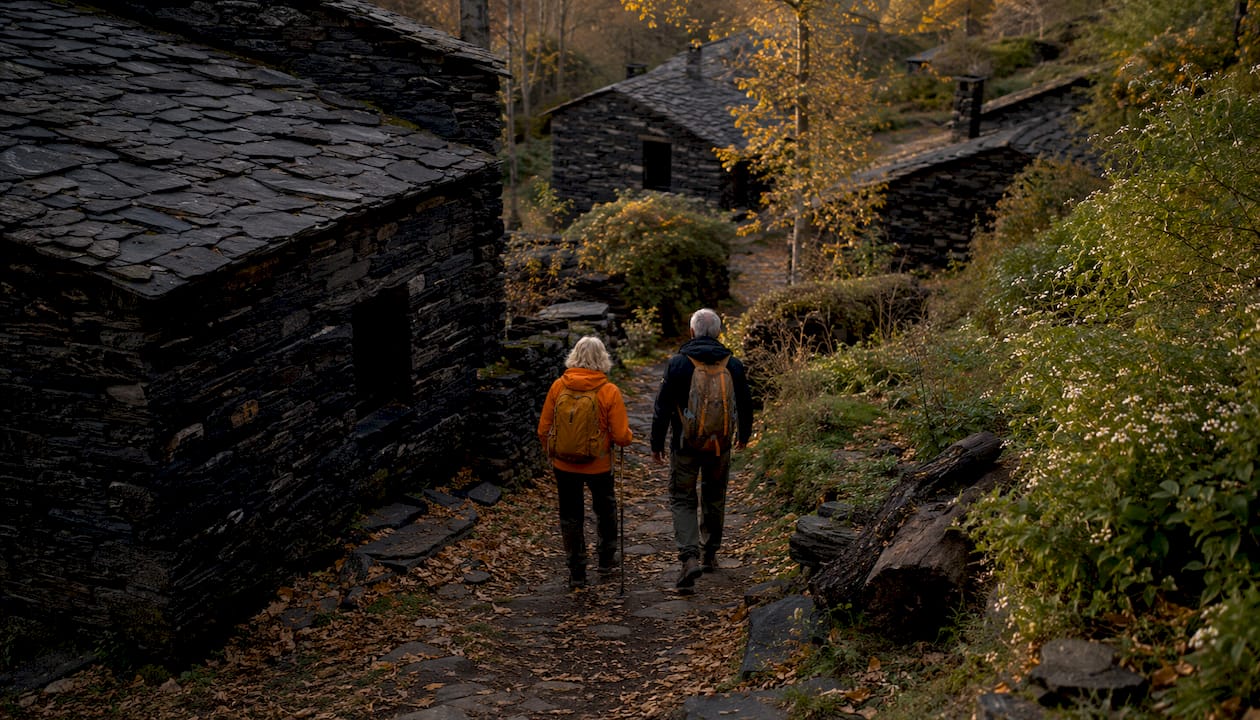 Una calle con casas de piedra negra y gente paseando