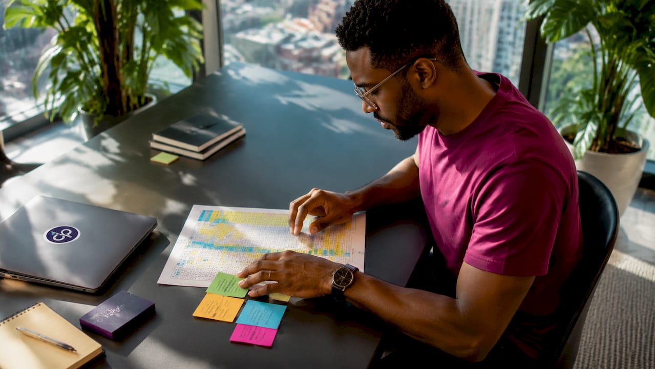 Side profile IT specialist reviewing data printouts