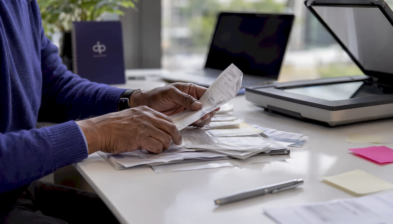 Hands sorting documents over table with scanner