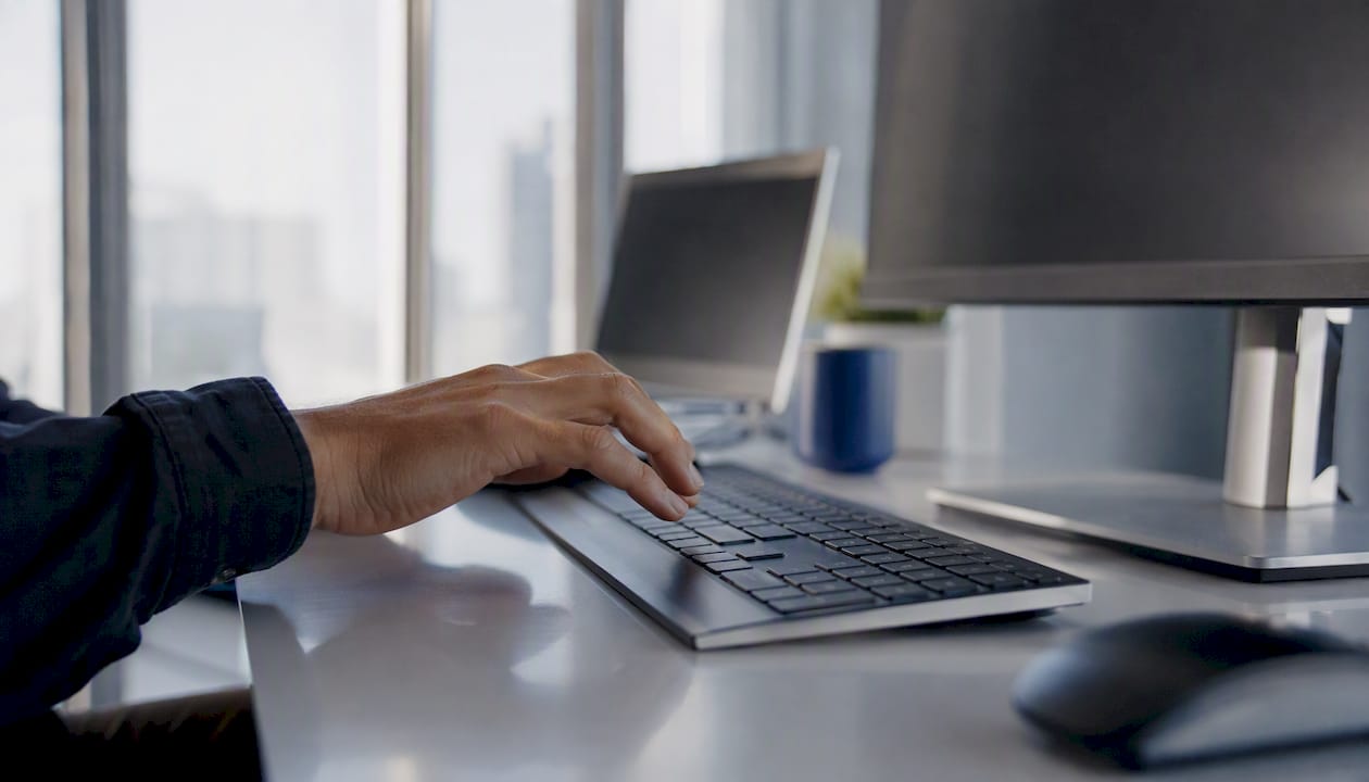 Close-up hand near keyboard suggesting digital automation