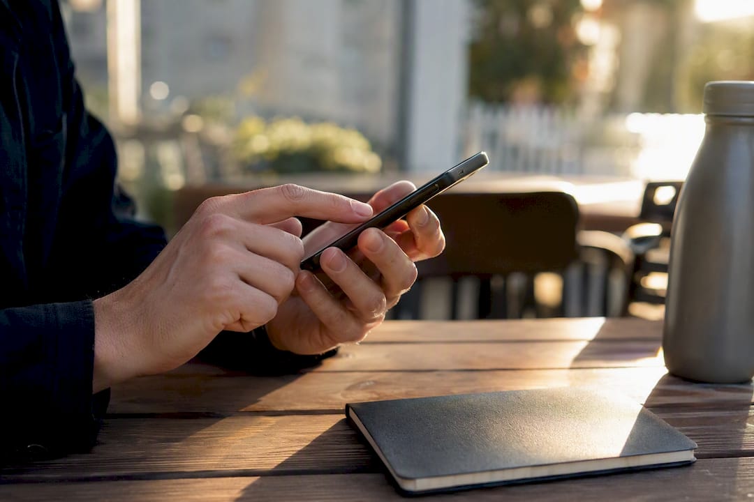 Hands setting SMS reminder on smartphone