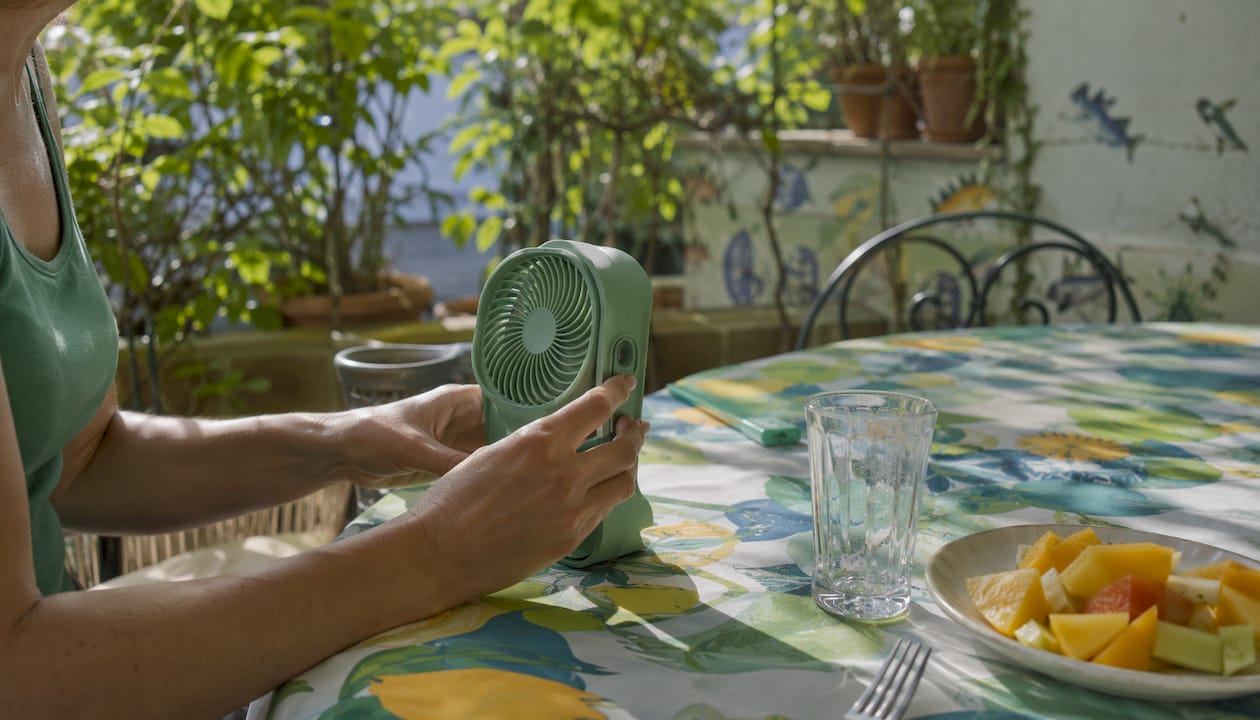 Hands adjusting mosquito repellent fan outdoors