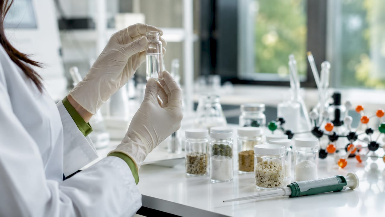 Hands holding vial with skin bacteria compounds