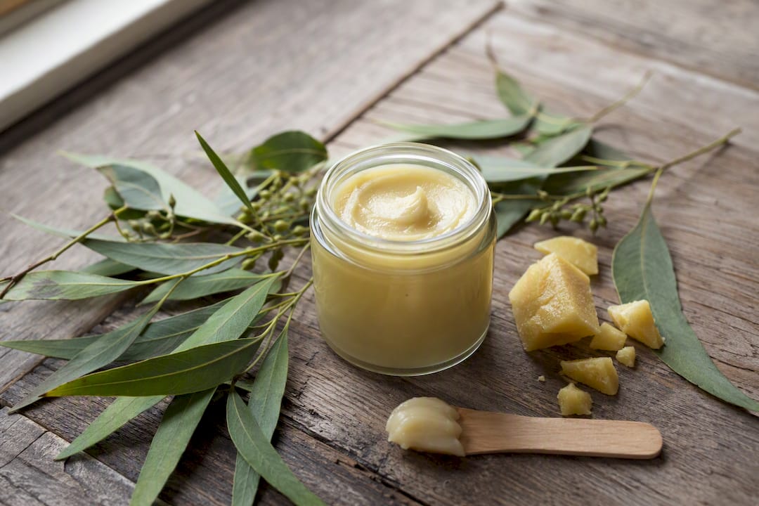 Close-up of natural insect repellent balm and botanicals